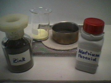 Natriumperoxid (gelbes Pulver) und Zink-Pulver (graues Pulver in der Metallschale) werden gemischt